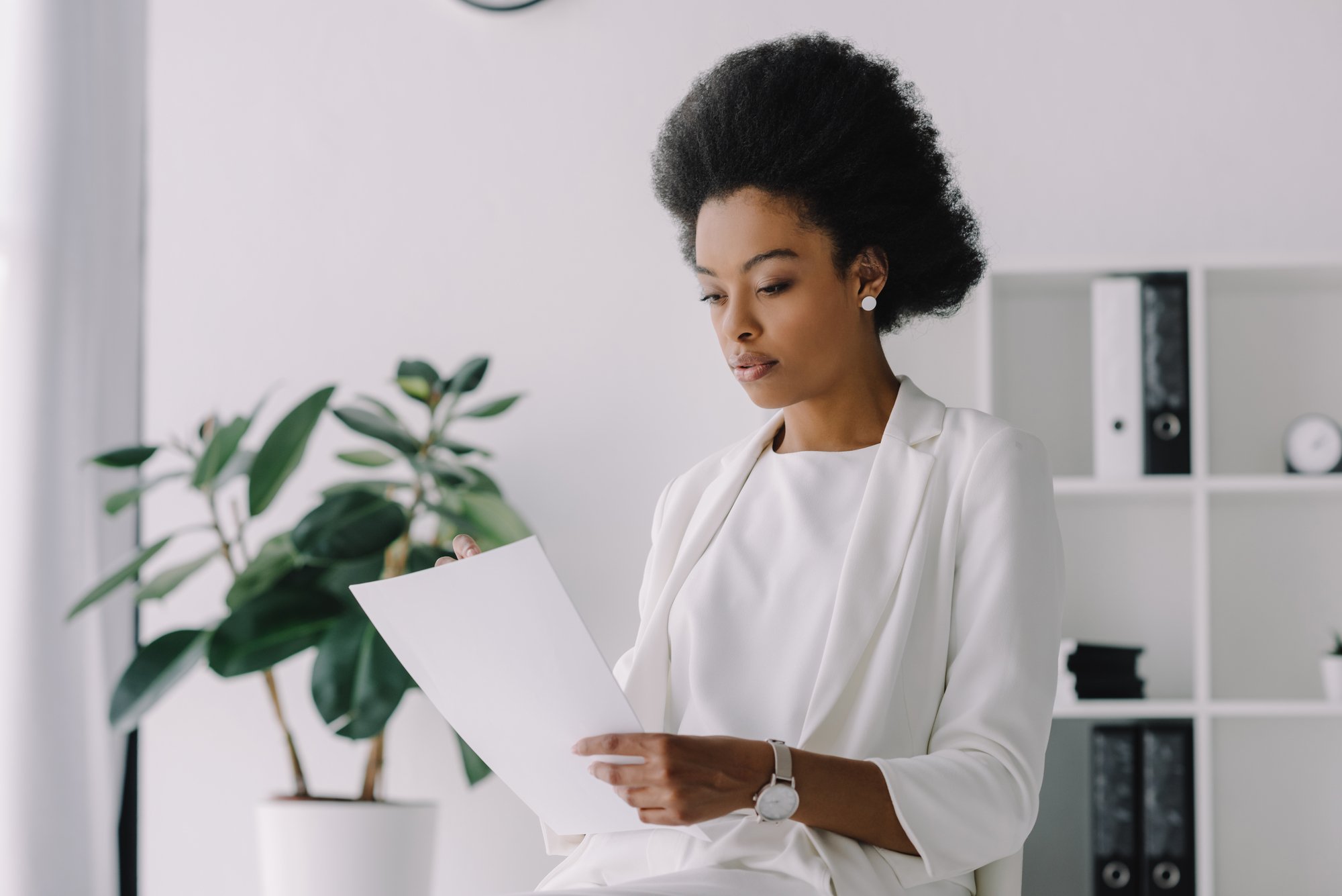 Attractive african american businesswoman reading document in office