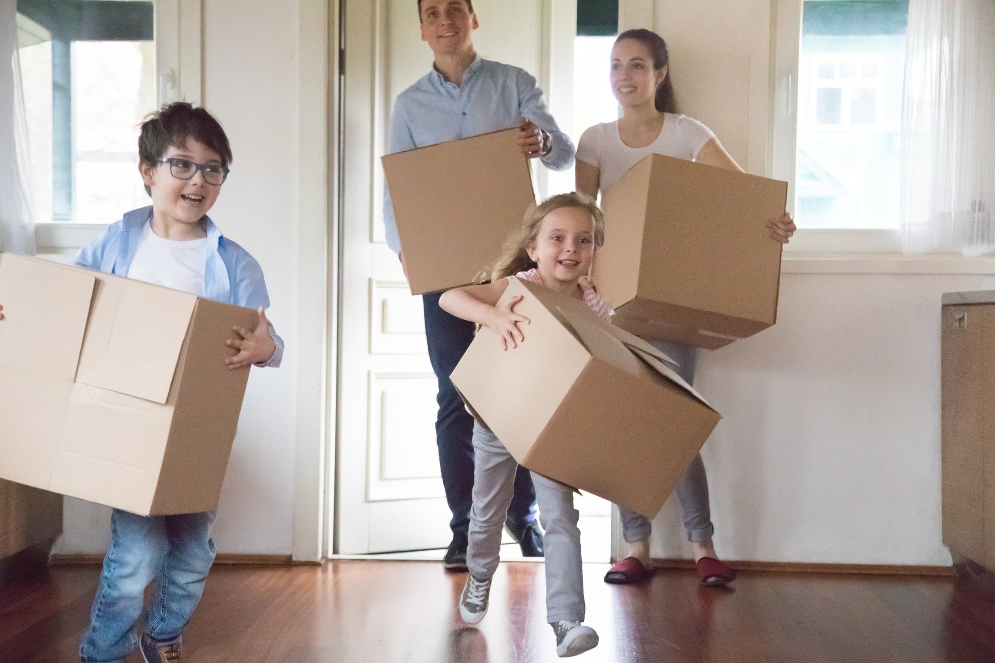 Excited kids running carrying boxes moving to new house