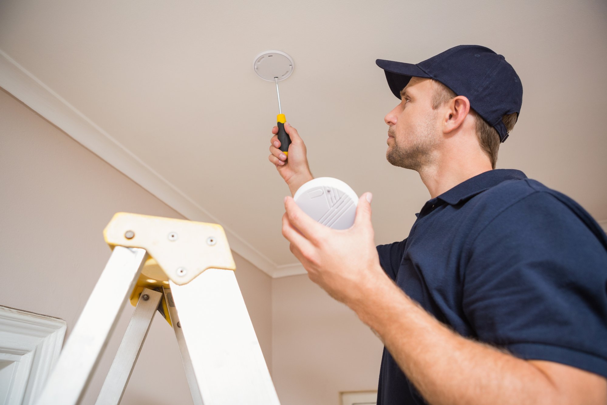 Handyman installing smoke detector