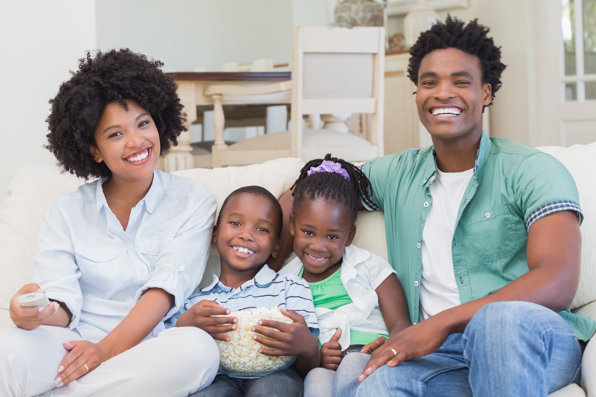 Happy family watching television eating popcorn