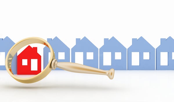 Magnifying glass selects or inspects a home in a row of houses