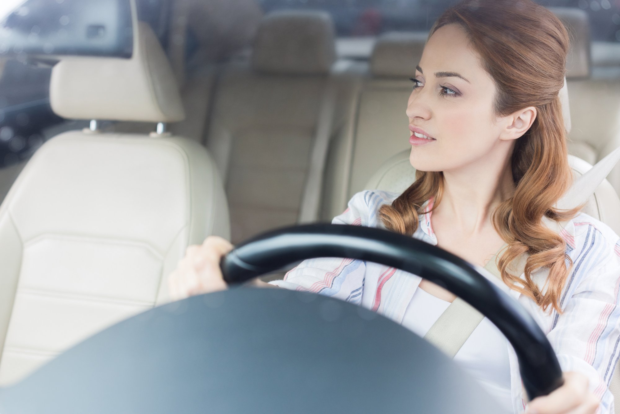Portrait of pensive woman looking away while driving car