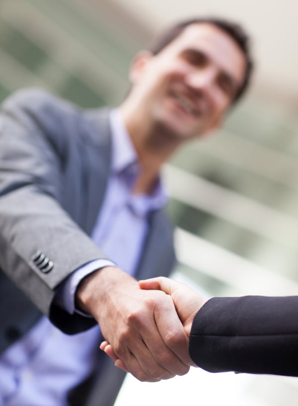 Business man giving a handshake to close the deal