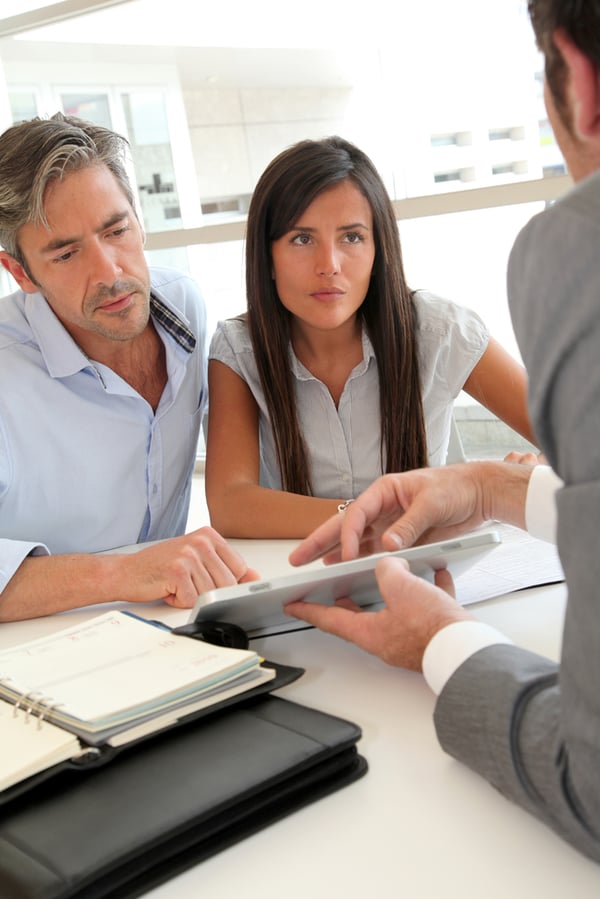 Real estate agent showing house plans on electronic tablet