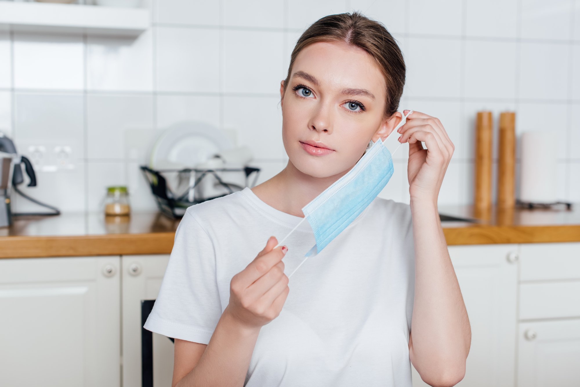 Young and attractive woman wearing medical mask at home