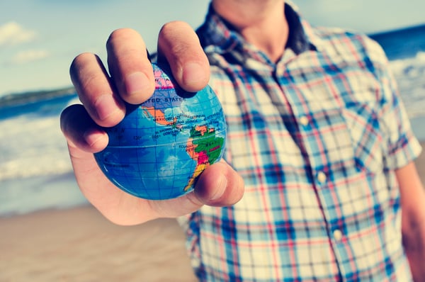 Young man with a world globe in his hand