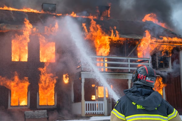 fireman hosing burning house