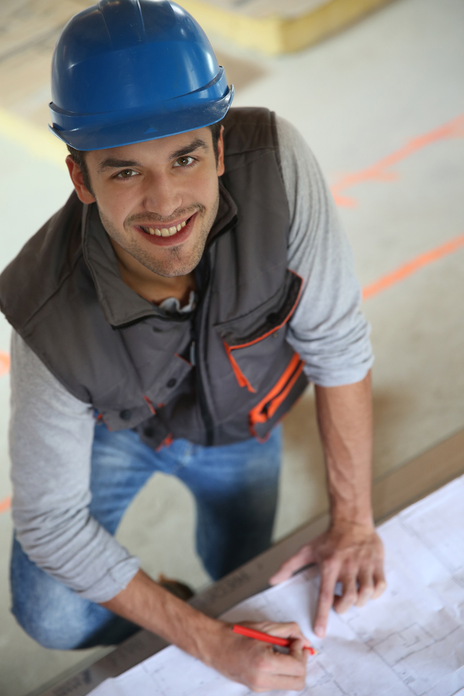 Construction worker checking blueprint